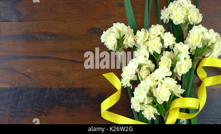 Spring ovehead with Springtime Erlicheer jonquil daffodils on a rustic wood table background. Stock Photo