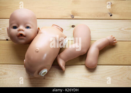 Broken Doll on Wooden Background Stock Photo