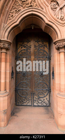 Arched door with huge & ornate hinges in imposing stone archway at entrance to historic Thomas Coats Memorial Baptist church in Paisley, Scotland Stock Photo