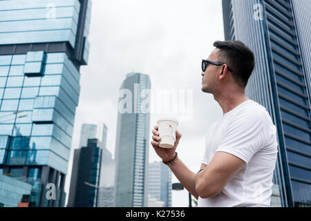 Young man looking up to the skyscrapers of a modern business dis Stock Photo