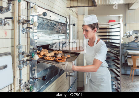 Baker is presenting freshly baked bread on tray Stock Photo