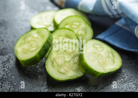 Sliced green cucumbers. Cucumber slices on black table. Stock Photo