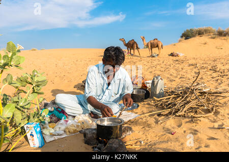 JAISALMER, RAJASTHAN, INDIA - MARCH 07, 2016: Horizontal picture of native indian man cooking in Thar Desert, located close to Jaisalmer, the Golden C Stock Photo