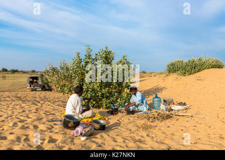 JAISALMER, RAJASTHAN, INDIA - MARCH 07, 2016: Wide angle picture of native indian men cooking in Thar Desert, located close to Jaisalmer, the Golden C Stock Photo