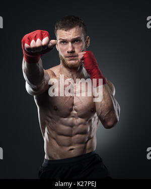 Muscular kickbox or muay thai fighter punching. Stock Photo