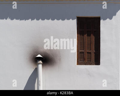 Brown window and chimney on a white wall Stock Photo