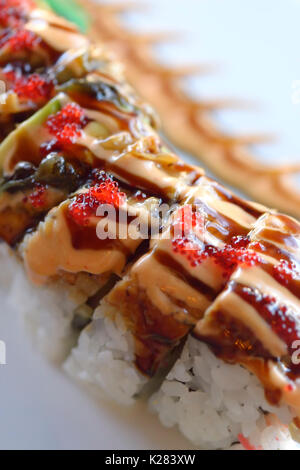 Artistic closeup of red dragon maki sushi roll with salmon and caviar Stock Photo