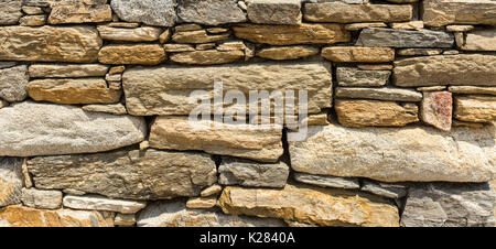 Detail of a dry stone wall structure, spot the lizard hiding in the wall. Stock Photo