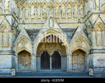 Ornate entrance with arched double doors surrounded by highly decorative stonework on west front of Salisbury cathedral, Wiltshire, England Stock Photo