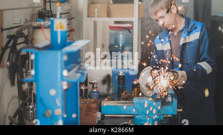 Professional car service - worker grinding metal construction with a circular saw, close up Stock Photo