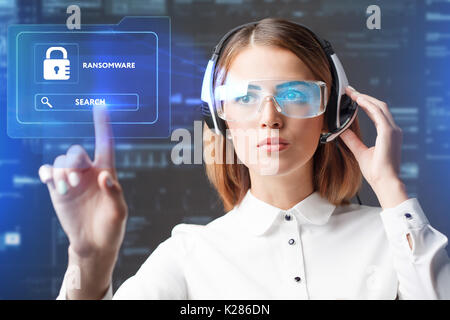 Business, Technology, Internet and network concept. Technology future. Young businesswoman working in virtual glasses, select the icon RANSOMWARE on t Stock Photo