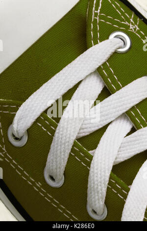 Lacing on a retro sneaker, close-up, on a blue wooden background. Stock Photo