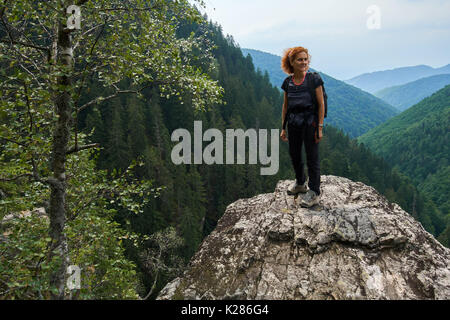 Happy hiker woman on the mountain peak, contemplating the view Stock Photo