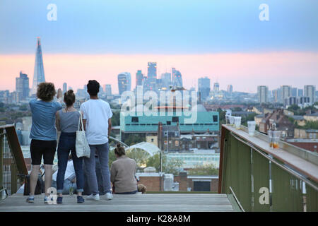 Young people view the London skyline at dusk from Frank's Café, the famous roof-top bar and restaurant on the multi-storey car park in Peckham, UK. Stock Photo