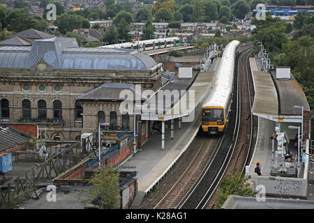 High level view of Peckham Rye Station in Southeast London, UK. Shows Southeastern network train at Platform 3 and the Victorian station building. Stock Photo