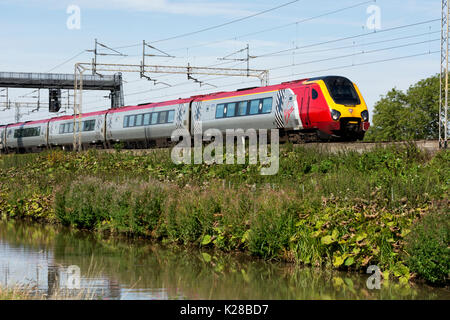 Virgin Trains Voyager on the West Coast Main Line alongside the Oxford Canal, Ansty, Warwickshire, UK Stock Photo