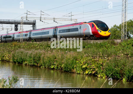 Virgin Trains Pendolino on the West Coast Main Line alongside the Oxford Canal, Ansty, Warwickshire, UK