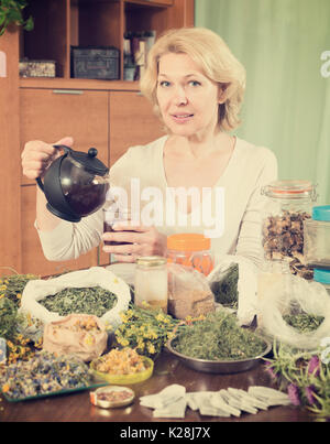 Senior  woman drinking herbal tea and smiling Stock Photo