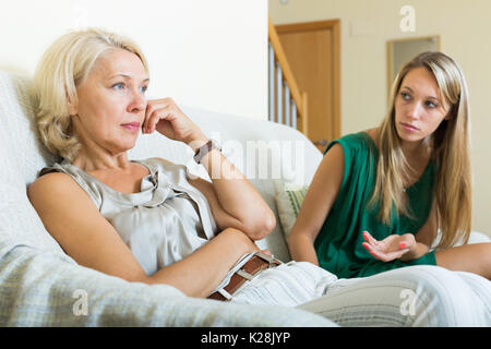 Upset woman and  mature mother having conflict in home Stock Photo