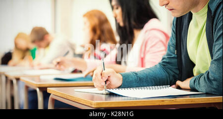 Young students writing notes in classroom Stock Photo
