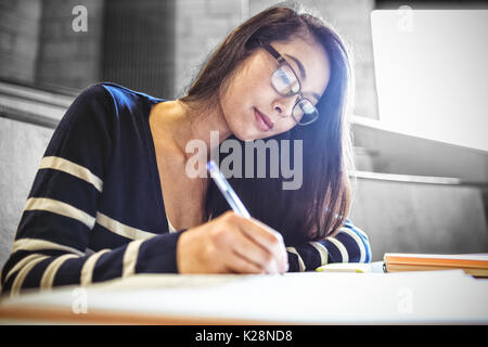 Focused student writing on notebook Stock Photo