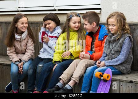 Little boys and girls sharing secrets as talking outdoor Stock Photo