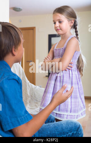 Little boy and girl having serious quarrel at home. Focus on girl Stock Photo