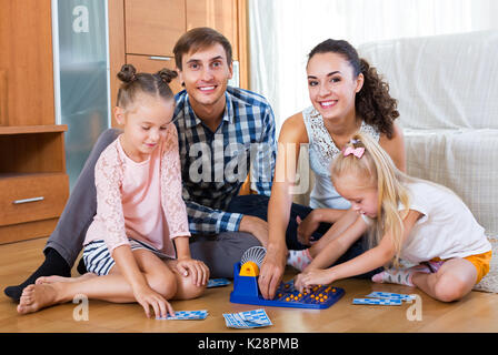 Cheerful parents and daughters with toy lotto at a home Stock Photo