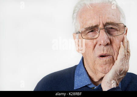 Studio Portrait Of Senior Man Suffering With Toothache Stock Photo