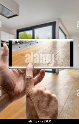 Two hands holding a mobile Smartphone and take a picture in a Modern luxury living room with wooden floor Stock Photo
