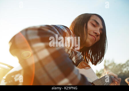 Handsome Guitarist Enjoying Summer Day Stock Photo