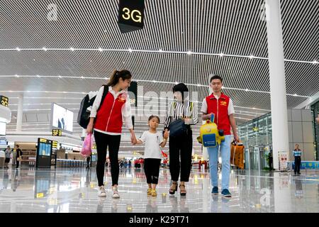 Chongqing, China. 29th Aug, 2017. Volunteers help passengers at the T3A terminal of the Jiangbei Airport in Chongqing, southwest China, Aug. 29, 2017. The T3A terminal and the third runway of the airport are put into operation on Tuesday. Credit: Liu Chan/Xinhua/Alamy Live News Stock Photo