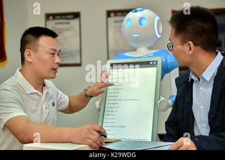 Yuncheng, China's Shanxi Province. 29th Aug, 2017. People interact with intelligent robots 'Fa Mengmeng' and 'Lyu Mengmeng' for legal advice at a law firm in Yuncheng, north China's Shanxi Province, Aug. 29, 2017. These two intelligent robots can provide some professional legal consultancy services for people. Credit: Cao Yang/Xinhua/Alamy Live News Stock Photo