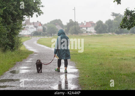 London, UK. 30th Aug, 2017. UK Weather. A woman walking her dog on Wimbledon Common as the rains arrive after a hot August bank holiday weekend Credit: amer ghazzal/Alamy Live News Stock Photo