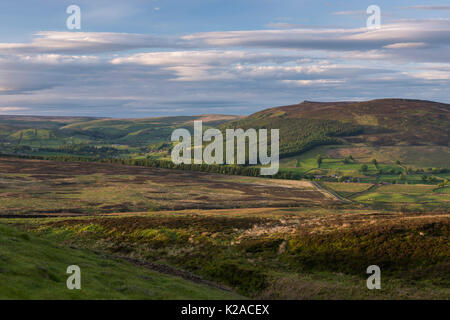 Scenic upland countryside (rolling hills of Wharfedale valley, Simon's Seat peak, sunlight & shadows on land, blue sky) - Yorkshire Dales, England, UK Stock Photo