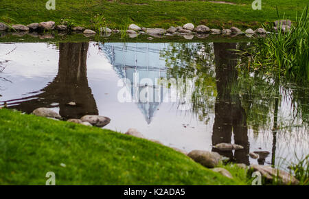 Reflection of glass pyramid building in a pond,  Linköping, Sweden - Tropikhuset Stock Photo