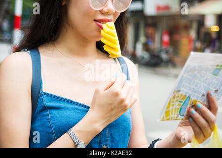 Happy tourist with pineapple slice on a stick on Asian trip Stock Photo