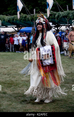 A woman wearing traditional northeastern Native American Regalia participates in Grand Entry. Stock Photo