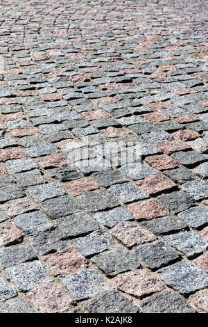 grey granite cobblestone pavement background fragment with uneven surface Stock Photo