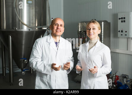 Portrait of two smiling brewery workers on beer production factory Stock Photo