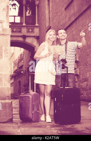 Man and woman on hollidays walking in city centre and takeing suitcases with you Stock Photo