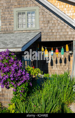 USA Maine ME Monhegan Island a wood shingled cottage with lobster floats buoys as decoration Stock Photo