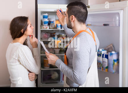 Professional workman visiting housewife customer for after-sales service of refrigerator Stock Photo