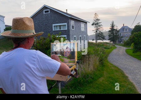 USA Maine ME Monhegan Island an artist is painting a home a gravel road at the end of the day Stock Photo