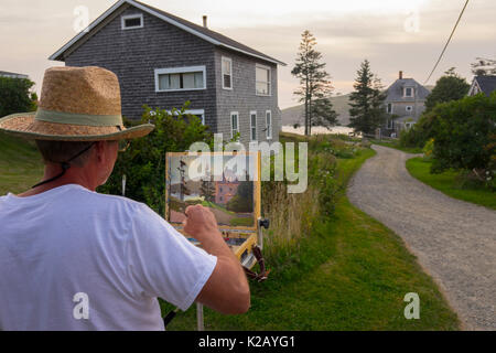 USA Maine ME Monhegan Island an artist is painting a home a gravel road at the end of the day Stock Photo