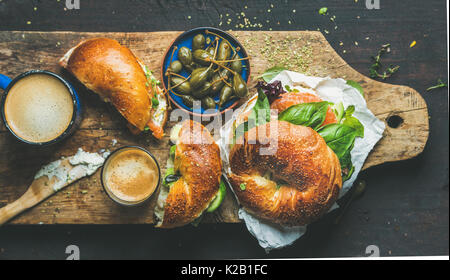 Breakfast with bagel, espresso coffee, capers on board, top view Stock Photo