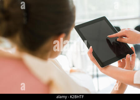 Doctor holding tablet and talking to her patient. Stock Photo
