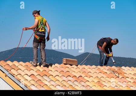 Roofers at work installing tiles on a new home in Provence, France Stock Photo