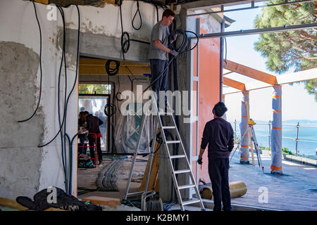 Electricians work on wiring a new home under construction on the French Riviera in southern France Stock Photo