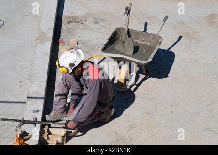 Construction laborer works on the details of building an in ground swimming pool Stock Photo